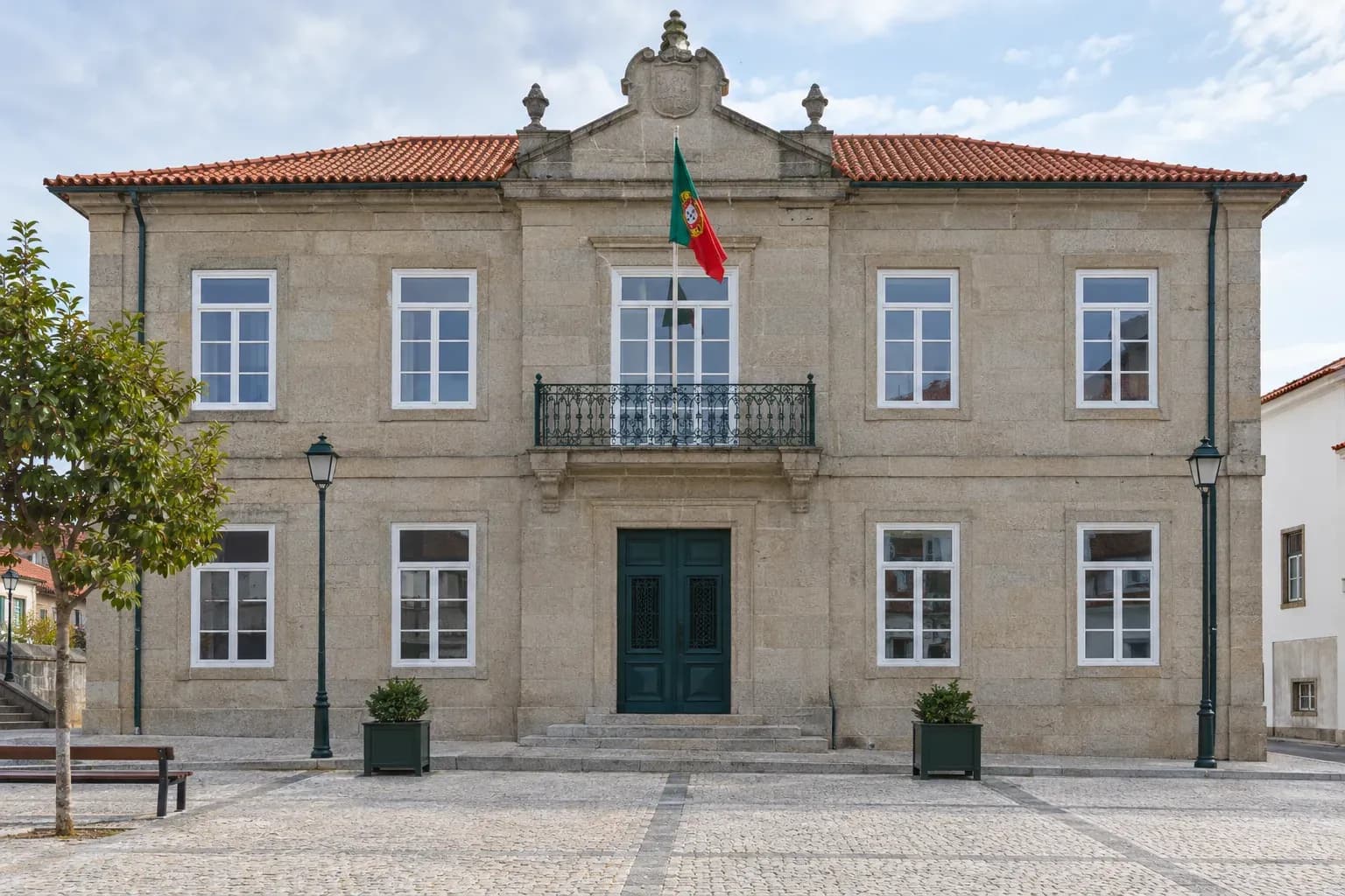 Edifício municipal com fachada de pedra e janelas brancas